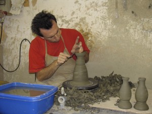 Man forming clay on a potters wheel at a ceramics factory in Deruta, Italy